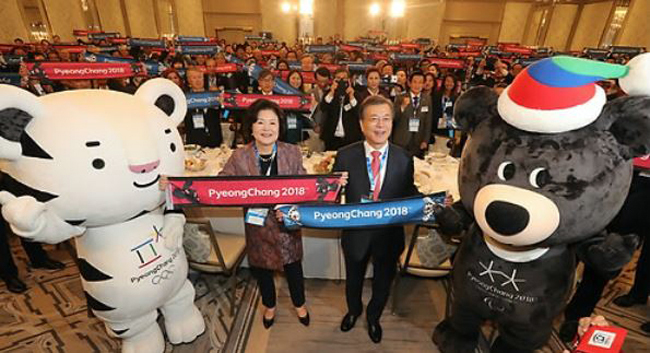 South Korean President Moon Jae-in and first lady Kim Jung-sook hold up publicity banners for the 2018 PyeongChang Winter Olympics during their meeting with Korean residents in New York on Sept. 18, 2017. (Yonhap)