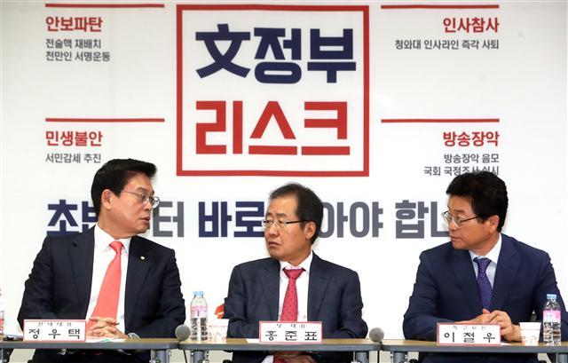 자유한국당 홍준표 대표(가운데)가 27일 청와대에서 열리는 영수회담에 불참키로 한 가운데, 이날 오전 서울 여의도 당사에서 열린 추석 민생점검회의에서 정우택 원내대표(왼쪽), 이철우 최고위원과 대화하고 있다.  [연합뉴스]