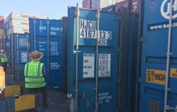 Workers check containers piled up on the southern port city of Busan on Sept. 17, 2017. (Yonhap)