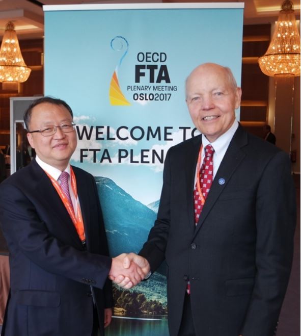 Han Seung-hee (L), commissioner of the National Tax Service, shakes hands with his US counterpart John Koskinen during a meeting in Oslo on Sept. 27, 2017, in this photo provided by the NTS the next day. (Yonhap)