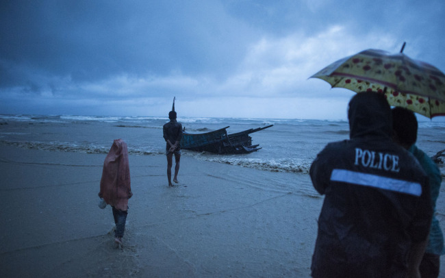 People come to see the boat where Rohingya Muslim refugees were found dead on the shore of Inani beach, near Cox’s Bazar on September 28, 2017. On September 28, at least 10 children and four women were killed when a boat carrying Rohingya fleeing violence in Myanmar capsized off Bangladesh, as the number of new arrivals topped 500,000 (AFP)