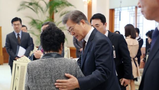 President Moon Jae-in greets a bereaved family member of a Navy service member who died in a 2002 inter-Korean naval clash in a special meeting held at the presidential office Cheong Wa Dae on Sept. 29, 2017. (Photo courtesy of Cheong Wa Dae) (Yonhap)