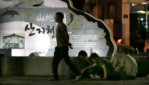 27일 밤 제주시 탐라문화광장에서 길 바닥에 자리를 잡은 사람들이 술판을 벌여 놓고 주변 상가와 행인들에게 피해를 주고 있다. (사진=연합뉴스)