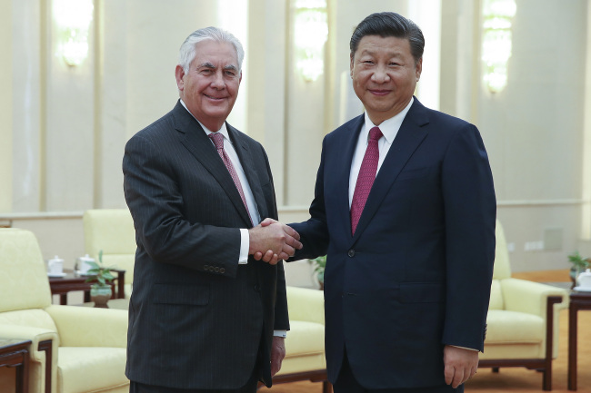 Chinese President Xi Jinping and US Secretary of State Rex Tillerson shake hands in Beijing on Saturday. AP-Yonhap