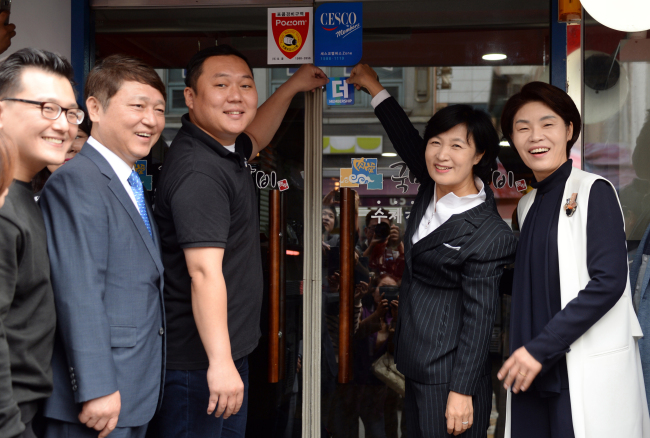 추미애 더불어민주당 대표(오른쪽 두번째)가 3일 서울시 강서구 화곡동에서 당원이 운영하는 전통갈비집을 ‘당원가게 1호’로 지정하는 기념식에 참석해 ‘더’ 인증 스티커를 붙이고 있다. 최재성 민주당 정당발전위원장(왼쪽 두번째), 한정애 의원(맨 오른쪽) 등이 지정식에 함께했다. [사진제공=연합뉴스]