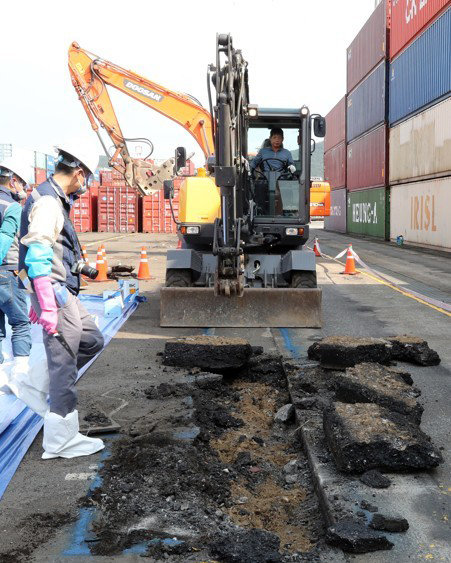 3일 부산시 남구 부산항 감만컨테이너 야적장에서 농림축산검역본부 관계자들이 굴착기를 동원해 야드의 아스팔트를 걷어내는 작업을 하고 있다. 당국은 오는 12일까지 관계부처 합동으로 붉은 독개미 군집 서식 여부를 파악할 방침이다. [사진제공=연합뉴스]