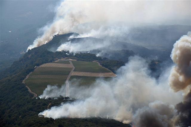 <YONHAP PHOTO-0971> Smoke rises as a wildfire burns in the hills north east of Napa, Calif., Monday, Oct. 9, 2017. Wildfires whipped by powerful winds swept through Northern California sending residents on a headlong flight to safety through smoke and flames as homes burned. (Michael Short/San Francisco Chronicle via AP)/2017-10-10 06:47:19/ <저작권자 ⓒ 1980-2017 ㈜연합뉴스. 무단 전재 재배포 금지.>