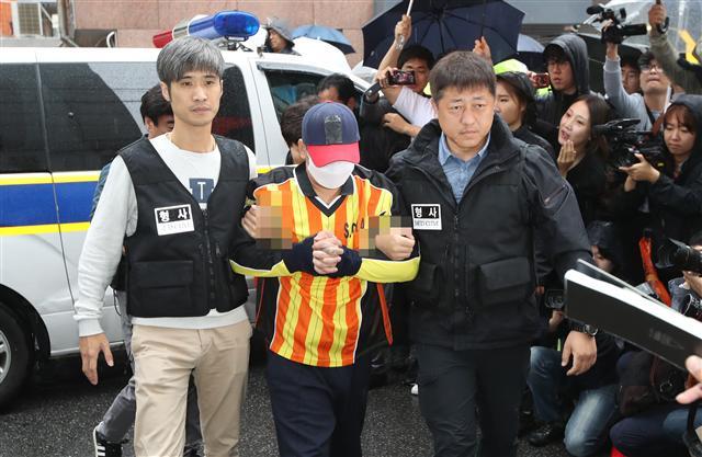 중학생 딸 친구 살해·시신 유기 사건의 피의자 ‘어금니 아빠’ 이모 씨가 11일 오전 현장 검증을 하기 위해 이씨가 거주했던 서울 중랑구 망우동의 자택으로 들어서고 있다. 이를 지켜보던 주민들은 분노의 목소리를 쏟아냈다. [연합뉴스]