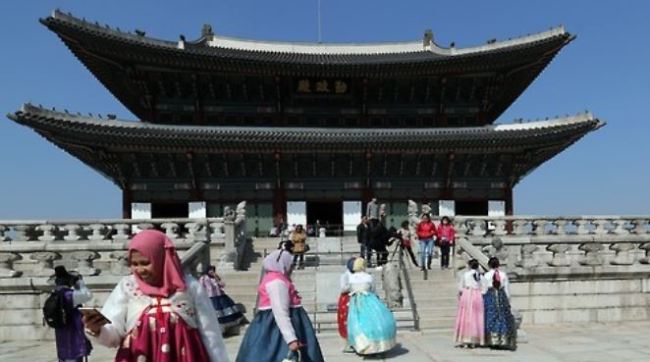 Visitors from Southeast Asia, dressed in "hanbok," the Korean traditional costume, tour Gyeongbok Palace in central Seoul. (Yonhap)