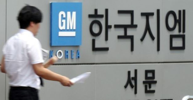 In this photo, taken July 6, 2017, a GM Korea worker passes by the west gate of the carmaker's plant in Bupyeong, just west of Seoul. (Yonhap)