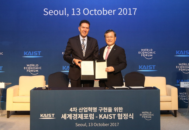 The head of WEF’s Center for the Fourth Industrial Revolution Murat Sonmez (left) and KAIST President Shin Sung-chul pose after signing a memorandum of understanding agreeing to become global partners in pushing forward the “fourth industrial revolution” at Lotte Hotel in Seoul, Friday. (KAIST)