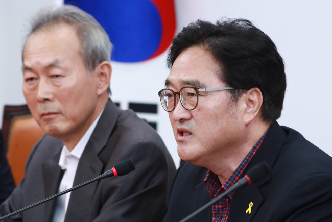 The ruling Democratic Party of Korea’s floor leader Rep. Woo Won-shik (right) speaks at a meeting on the 2014 Sewol ferry disaster at the National Assembly on Sunday. Yonhap