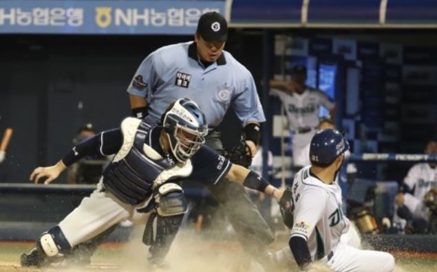 In this file photo taken July 9, 2017, Kim Seong-uk of the NC Dinos (R) slides home safely against the Doosan Bears in the clubs' Korea Baseball Organization regular season game at Masan Stadium in Changwon, South Gyeongsang Province. The two teams will meet in the second round series in the postseason starting Oct. 17, 2017. (Yonhap)