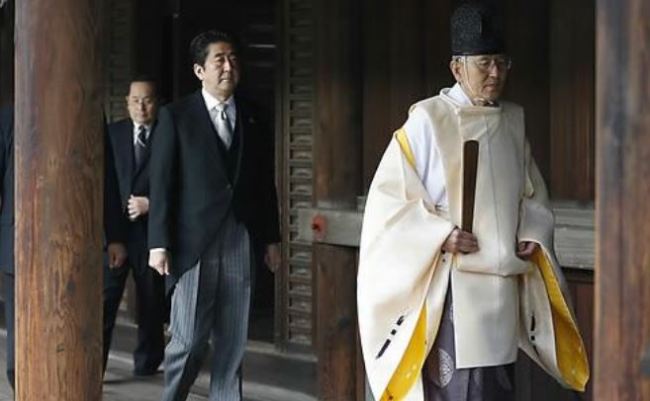 Japanese Prime Minister Shinzo Abe, second from right, follows a Shinto priest to pay respect for the war dead at Yasukuni Shrine in Tokyo Thursday, Dec. 26, 2013. Abe visited Yasukuni war shrine in a move sure to infuriate China and South Korea. The visit to the shrine, which honors 2.5 million war dead including convicted class A war criminals, appears to be a departure from Abe's pragmatic approach to foreign policy, in which he tried to avoid alienating neighboring countries. It was the first visit by a sitting prime minister since Junichiro Koizumi went to mark the end of World War II in 2006. (AP)
