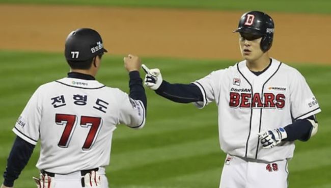 Min Byung-hun of the Doosan Bears (R) celebrates with his first base coach Jeon Hyung-do after a base hit in the bottom of the first in Game 1 of the Korea Baseball Organization postseason series against the NC Dinos at Jamsil Stadium in Seoul on Oct. 17, 2017. (Yonhap)