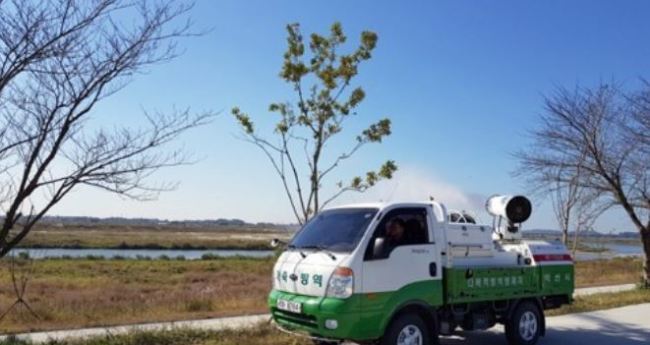 A truck is sterilizing near a river in Iksan on Oct. 20, 2017, after the avian influenza virus was detected in droppings of wild birds from the area, in this photo provided by the city government. (Yonhap)