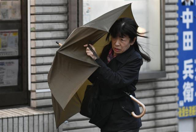 <YONHAP PHOTO-1228> epa06283274 A woman uses an umbrella to shield herself from strong wind generated by typhoon Lan in Tokyo, Japan, 23 October 2017. Typhoon Lan made landfall in Izu Peninsula, west of Tokyo, before hitting the Japanese capital overnight disrupting transportation in early morning. EPA/FRANCK ROBICHON/2017-10-23 08:23:24/ <저작권자 ⓒ 1980-2017 ㈜연합뉴스. 무단 전재 재배포 금지.>