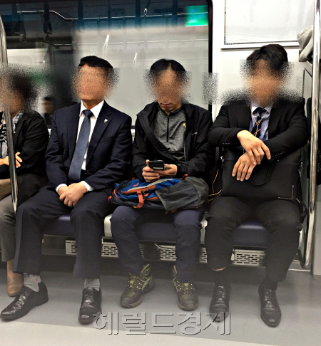 26일 아침 8시 2호선 신조차량 좌석에 앉은 남성 승객들의 모습. 건장한 남성들끼리 앉아도 비좁지 않다. [사진=김유진 기자/kacew@heraldcorp.com]