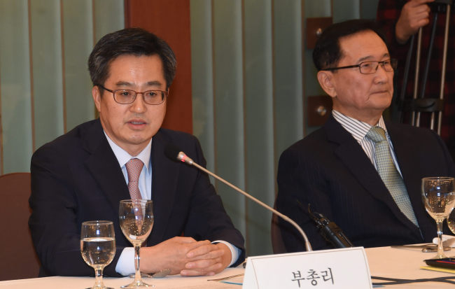 Finance Minister Kim Dong-yeon (left) speaks at a meeting with former deputy prime ministers and ministers in Seoul on Friday. Yonhap