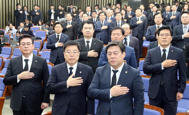자유한국당 정우택 원내대표와 의원들이 30일 오전 국회에서 열린 의원총회에서 국기에 경례를 하고 있다. 이날 한국당 의원들은 정 원내대표가 제안한 ‘국회 보이콧 철회후 국감 복귀’를 논의하기 위한 의총에 검은 양복을 입고 참석했다. [연합뉴스]