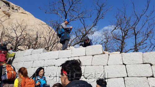 29일 북한산 등산로에 있는 북한산성 성벽에 등산객들이 자리 잡았다. 출입금지 푯말이 무색하다. [사진=김진원 기자 / jin1@heraldcorp.com]