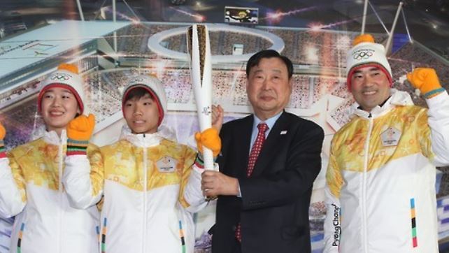 Lee Hee-beom (second from R), head of the organizing committee for the 2018 PyeongChang Winter Olympics holds up the Olympic torch unveiled on Feb. 9, 2017, at Gangneung Hockey Centre in Gangneung, Gangwon Province. (Yonhap)