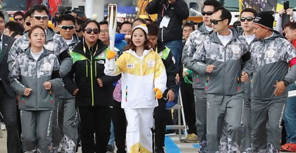 South Korean figure skater You Young (C) carries the torch for the 2018 PyeongChang Winter Olympics on Incheon Bridge in Incheon on Nov. 1, 2017. (Yonhap)