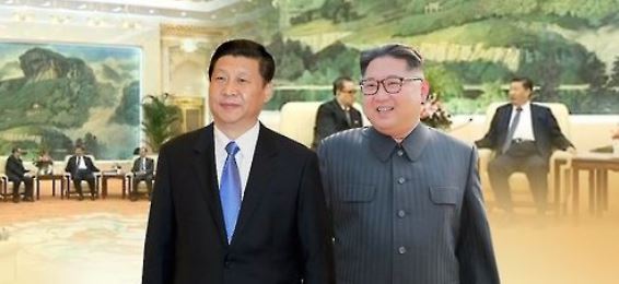 Chinese President Xi Jinping (L) and North Korean leader Kim Jong-un in a photo provided by Yonhap News TV (Yonhap)