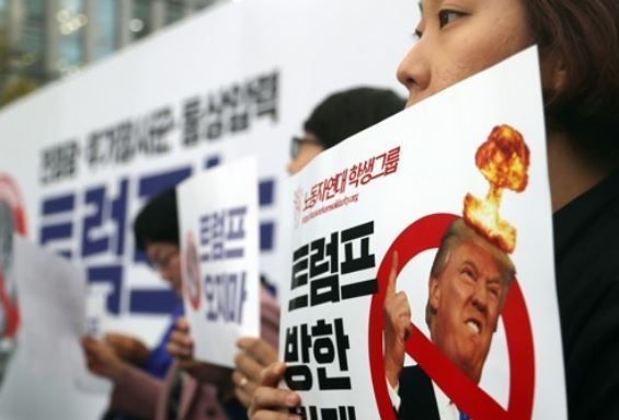 A protester is holding a sign opposing Trump's visit to Korea in a rally in Gwanghwamun Square on Nov. 1, 2017. (Yonhap)