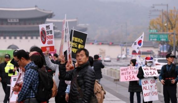 The photo, taken on Nov. 2, 2017, shows two divided groups of people each holding pro- and anti-U.S. signs in Gwanghwamun Square. (Yonhap)
