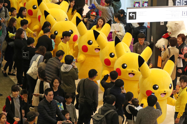 PIKACHU PARADE -- Several people dressed as “Pokemon” character Pikachu parade at the Pokemon Festa in Jamsil, Seoul, on Sunday. The festival at Lotte World Tower began on Saturday and runs through Nov. 12. (Yonhap)