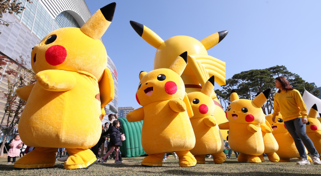 PIKACHU PARADE -- Several people dressed as “Pokemon” character Pikachu parade at the Pokemon Festa in Jamsil, Seoul, on Sunday. The festival at Lotte World Tower began on Saturday and runs through Nov. 12. (Yonhap)