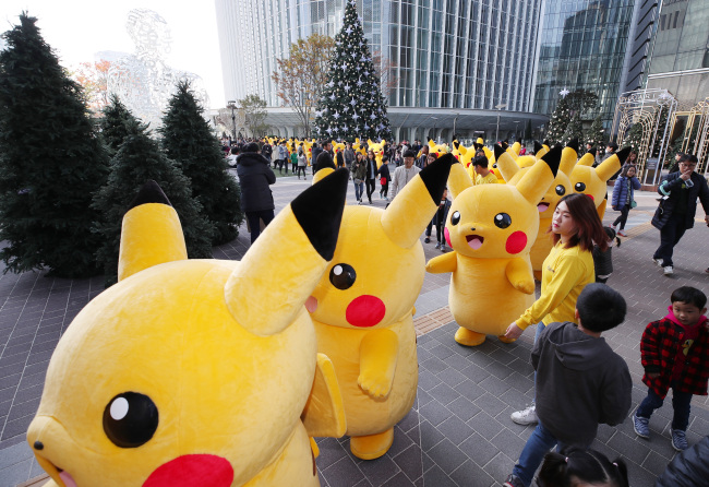 PIKACHU PARADE -- Several people dressed as “Pokemon” character Pikachu parade at the Pokemon Festa in Jamsil, Seoul, on Sunday. The festival at Lotte World Tower began on Saturday and runs through Nov. 12. (Yonhap)