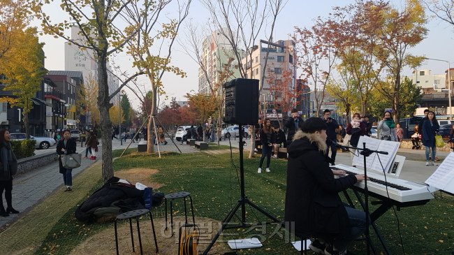 4일 저녁 서울 마포구 연남동 경의선숲길 공원에서 길거리공연(버스킹) 팀이 연속으로 공연을 하고 있다. 공연팀 뒤쪽으로 아파트 단지가 보인다.
