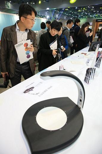 관람객들이 다양한 디자인용품을 보며 즐거워하고 있다.