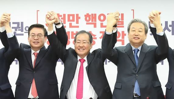 Hong Joon-pyo (C), the leader of the main opposition Liberty Korea Party, poses with party lawmakers during an event marking the return of former renegade lawmakers at the party headquarters in Seoul on Nov. 9, 2017. (Yonhap)