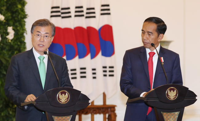 South Korea’s President Moon Jae-in (left) and Indonesian President Joko “Jokowi” Widodo partake in a summit in Jakarta(Yonhap)