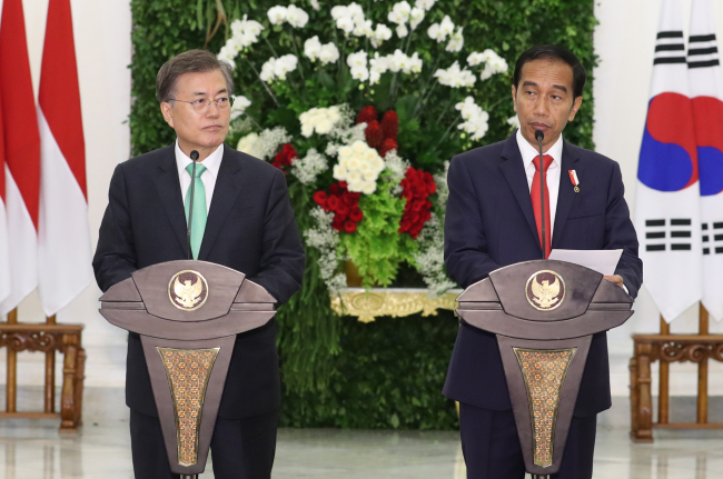 South Korea’s President Moon Jae-in (left) and Indonesian President Joko “Jokowi” Widodo partake in a summit in Jakarta on Thursday. (Yonhap)