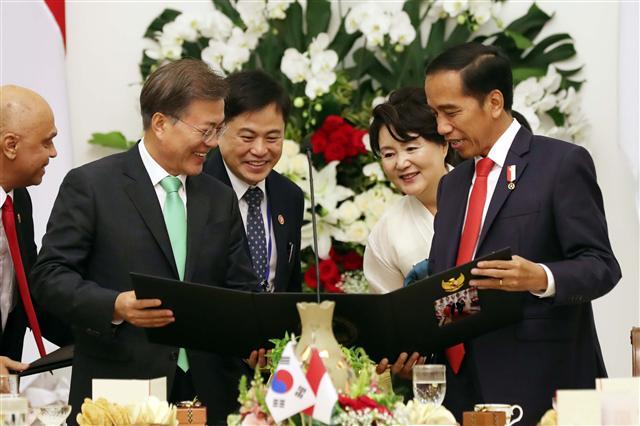 인도네시아를 국빈 방문중인 문재인 대통령 내외가 9일 보고르 대통령궁 가루다홀에서 열린 조코 위도도 인도네시아 대통령 주최 국빈만찬에서 사진첩을 선물 받고 있다.  [연합뉴스]