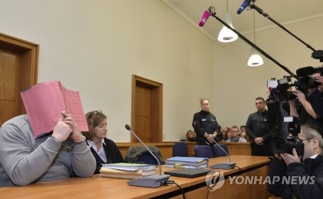28일(현지시간) 독일 경찰은 입원 환자들에게 약물을 주입해 살해한 혐의로 종신형을 선고받은 남성 간호사 닐스 회겔이 적어도 90명가량의 환자를 살해했다고 밝혔다. 경찰은 해당 병원에서 숨진 환자들의 시신을 검시한 결과, 추가 살인의 증거를 발견했다고 덧붙였다.
회겔은 2명을 살해하고 다른 2명에 대한 살인 미수 혐의로 지난 2015년 무기징역을 선고받았다. 사진은 2015년 2월 26일 올덴부르크 지방법원에서 얼굴을 가리고 있는 회겔(왼쪽)의 모습. (사진=연합뉴스-AP)