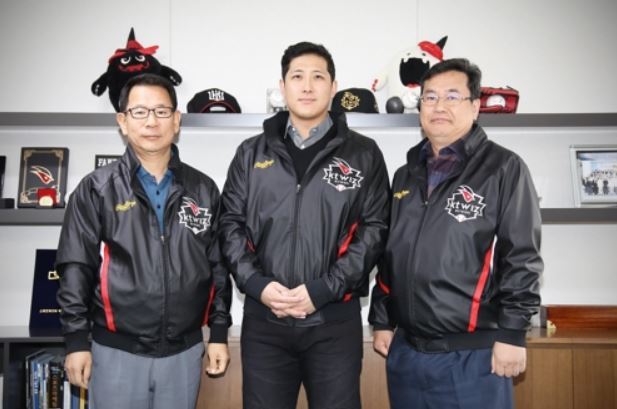 In this photo provided by the KT Wiz baseball club, former major league third baseman Hwang Jae-gyun (C) stands next to Wiz president Yoo Tae-yeol (L) and general manager Lim Jong-taek after signing a four-year deal worth 8.8 billion won (US$7.9 million) with the Korea Baseball Organization team at KT Wiz Park in Suwon, Gyeonggi Province. (Yonhap)