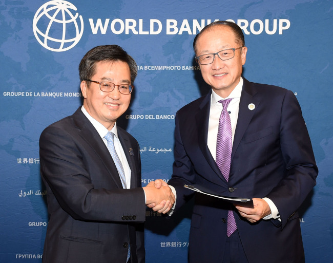 World Bank President Jim Yong Kim (right) and Korean Finance Minister Kim Dong-yeon pose after signing a memorandum of understanding to expand the capacity of the World Bank Group Korea Office in Songdo, Incheon on Oct. 14. (Yonhap)