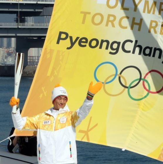 Ha Ji-min, Asian Games gold medalist in sailing, carries the Olympic flame for the 2018 PyeongChang Games as part of the torch relay in Busan on Nov. 6, 2017. (Yonhap)