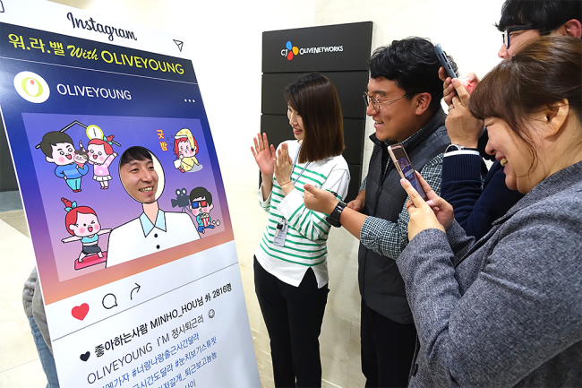 [사진=올리브영 직원들이 사내에 마련된 ‘워라밸 위드 올리브영 캠페인’ 포토존에서 자유롭게 사진을 찍고 있는 모습.]