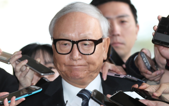 Former National Intelligence Service chief Lee Byung-kee is surrounded by reporters at the Seoul Central District Prosecutors’ Office on Monday. (Yonhap)
