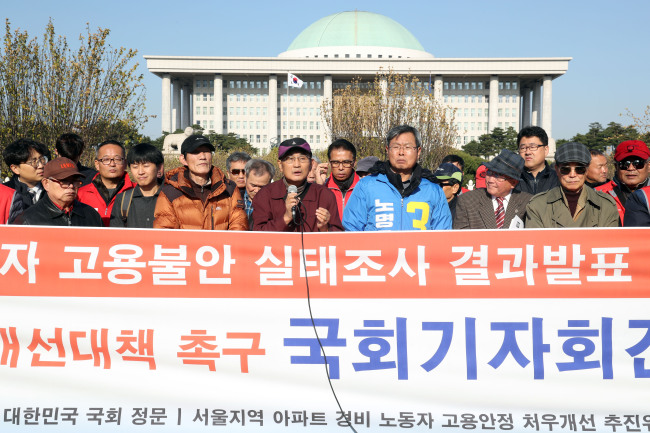 Members of civic groups advocating the rights of security guards hold a press conference in front of the National Assembly in Seoul on Wednesday. (Yonhap)