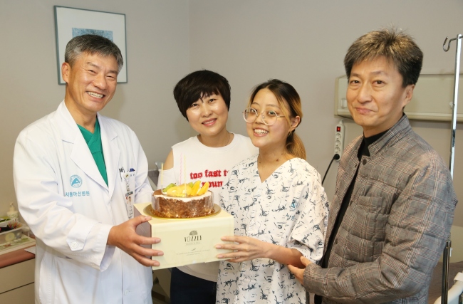 오화진 씨는 공교롭게 생체 폐 이식 수술을 받고 6일이 나 깨어난 지난달 27일 중환자실에서 20번째 생일을 맞았다. 수술을 집도한 박승일 서울아산병원 흉부외과 교수가 일반 병실로 옮겨 회복 중인 화진 씨를 위해 생일 케이크를 전달하며 축하해 주고 있다. 왼쪽부터 박 교수, 화진 씨 어머니 김해영 씨, 화진 씨, 아버지 승택 씨. [제공=서울아산병원]