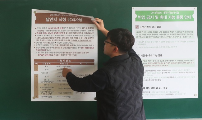 포항 지진 여파로 대학수학능력시험이 1주일 뒤로 연기된 16일 오전 경기도 수원시의 한 시험장에서 관계자가 시험 안내문을 철거하고 있다.[사진제공=연합뉴스]