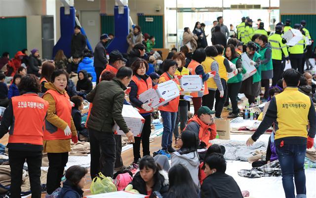 15일 오후 포항시 흥해읍사무소 인근 체육관에 지진을 피해서 대피한 주민들이 배식을 받고 있다. [연합뉴스]
