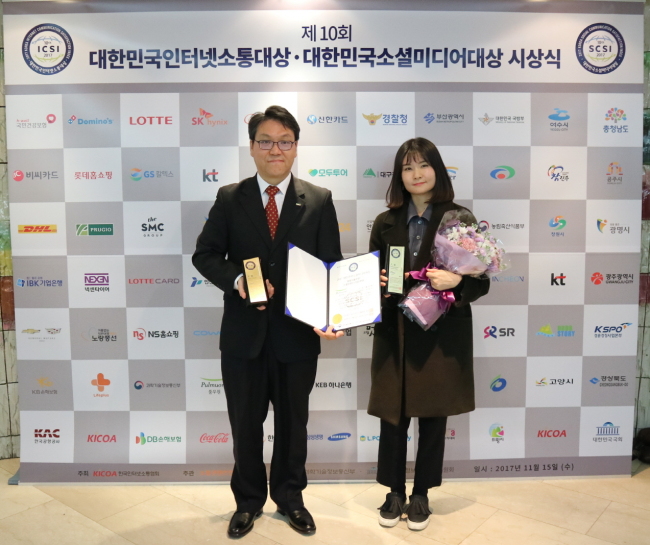 [사진=풀무원 SNS 채널 담당 진영주 팀장(왼쪽)과 직원(오른쪽)이 포토월에서 기념 사진을 찍고 있다.]